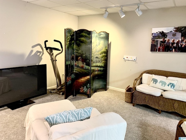 living area with carpet, rail lighting, a drop ceiling, and baseboards