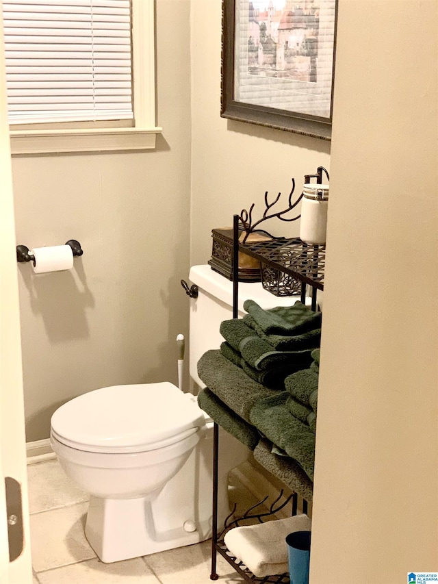 half bathroom featuring toilet and tile patterned flooring