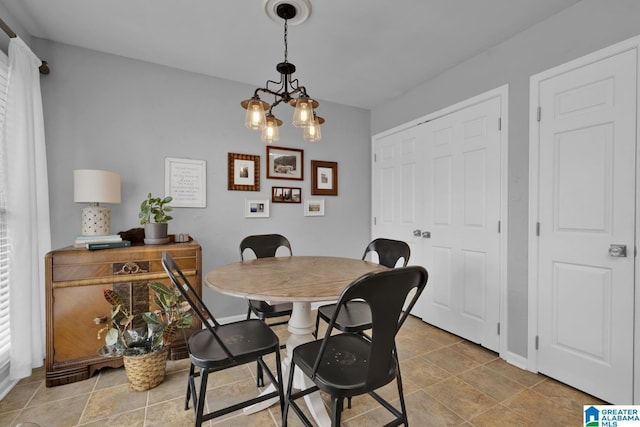 dining room with a chandelier and baseboards