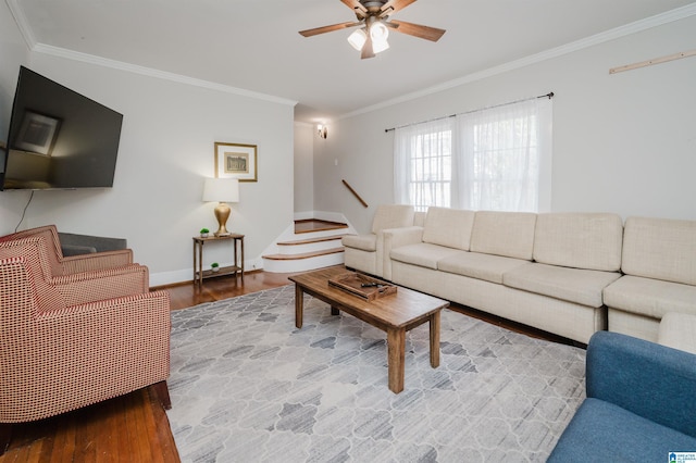 living area featuring a ceiling fan, stairway, wood finished floors, and ornamental molding