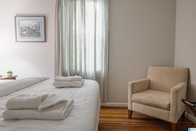 bedroom with baseboards, multiple windows, and wood finished floors