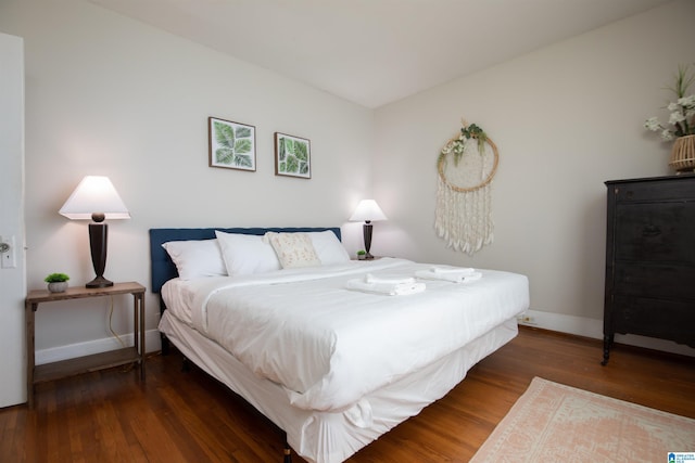 bedroom with baseboards and wood finished floors