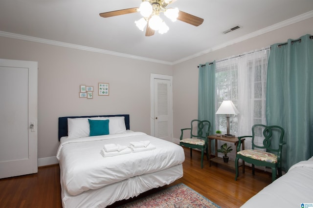 bedroom featuring visible vents, crown molding, wood finished floors, a closet, and a ceiling fan