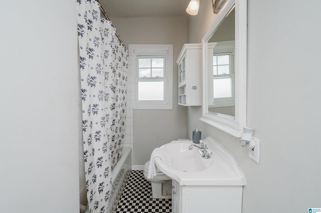 bathroom with vanity, tile patterned floors, toilet, and shower / bath combo with shower curtain