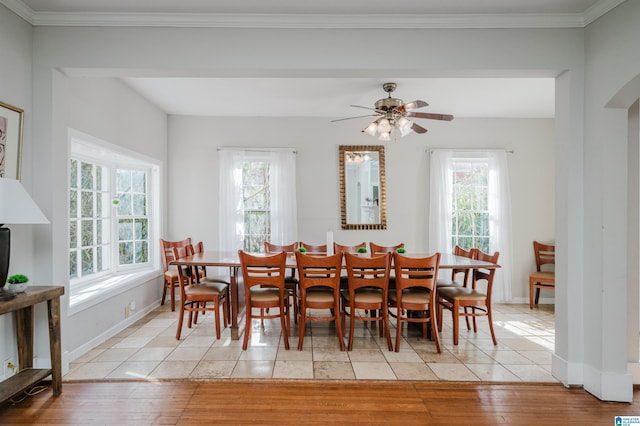 dining room featuring baseboards, plenty of natural light, light wood-style floors, and crown molding