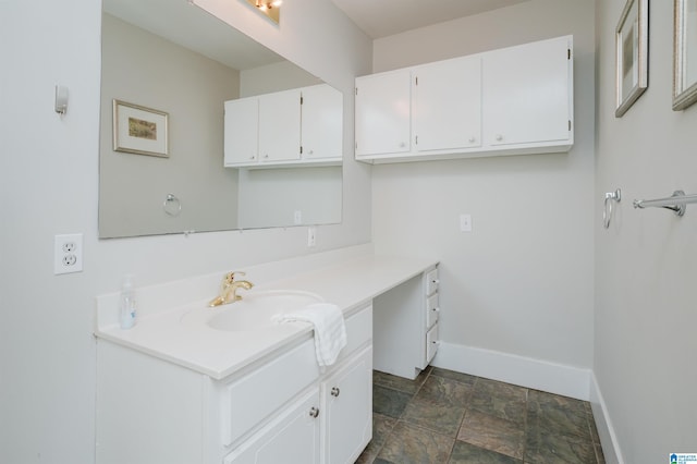 bathroom featuring vanity, baseboards, and stone finish flooring