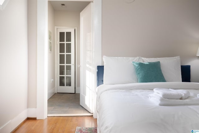 bedroom featuring wood finished floors and visible vents