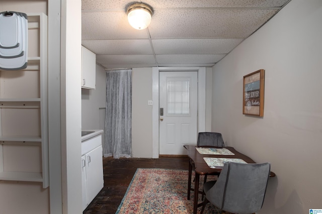 interior space featuring a paneled ceiling and dark wood finished floors