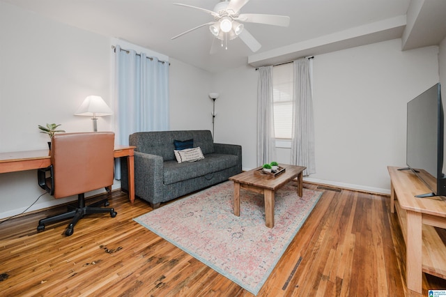 living area with baseboards, ceiling fan, and hardwood / wood-style flooring