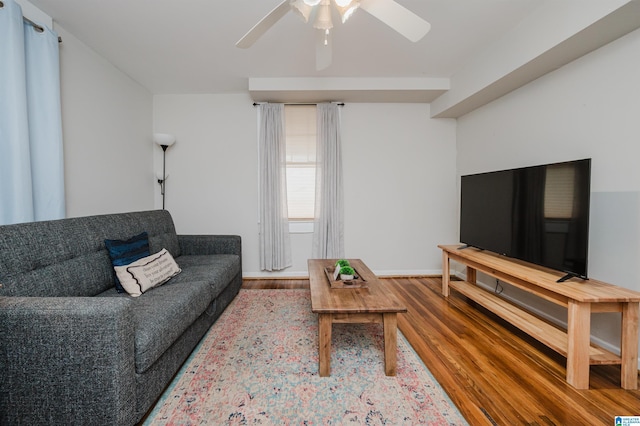 living room with a ceiling fan, wood finished floors, and baseboards