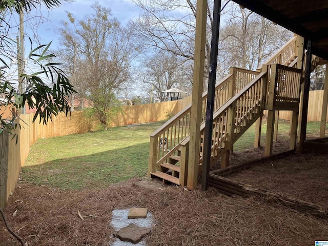 view of yard with a fenced backyard and stairs