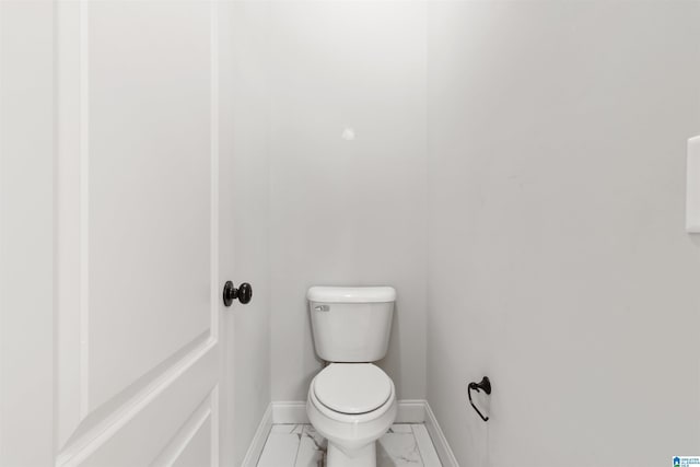 bathroom with marble finish floor, toilet, and baseboards