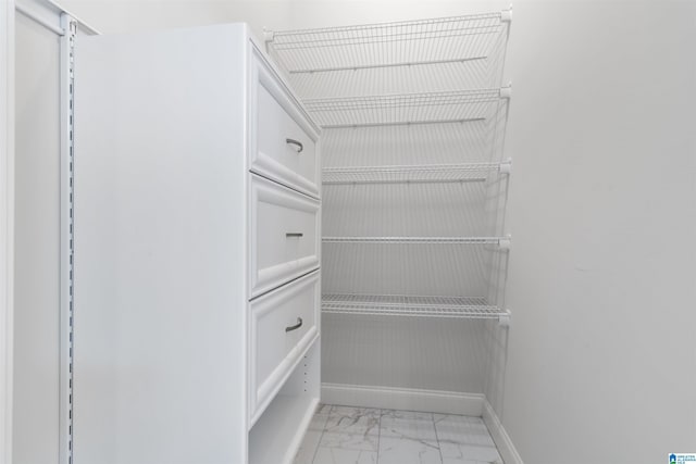 walk in closet with marble finish floor