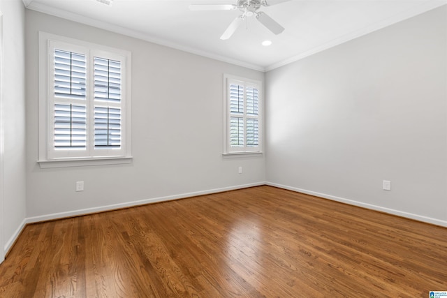 spare room with ornamental molding, wood finished floors, a ceiling fan, and baseboards