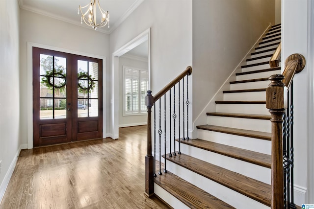 entrance foyer with ornamental molding, french doors, wood finished floors, and baseboards