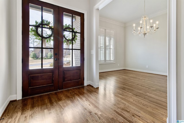 entryway with a notable chandelier, wood finished floors, baseboards, ornamental molding, and french doors