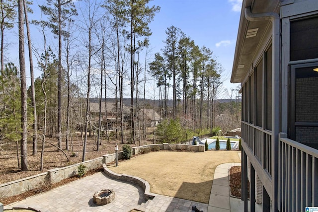 view of patio / terrace featuring an outdoor fire pit and a swimming pool