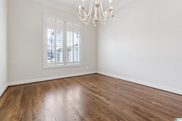 spare room featuring ornamental molding, a chandelier, dark wood finished floors, and baseboards