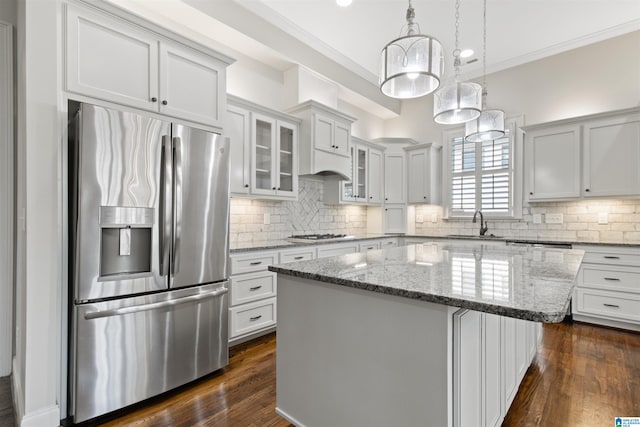 kitchen with ornamental molding, appliances with stainless steel finishes, a sink, and decorative backsplash