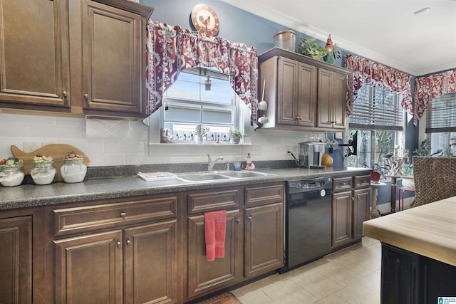 kitchen featuring dark countertops, a healthy amount of sunlight, black dishwasher, and a sink