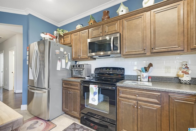 kitchen with brown cabinets, a toaster, appliances with stainless steel finishes, crown molding, and tasteful backsplash