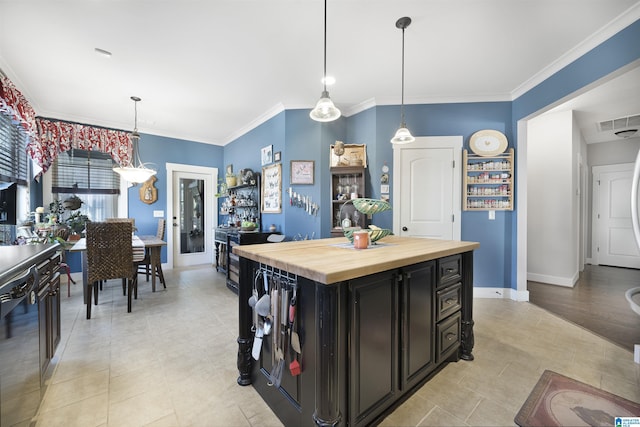 kitchen with visible vents, baseboards, ornamental molding, wood counters, and dark cabinets