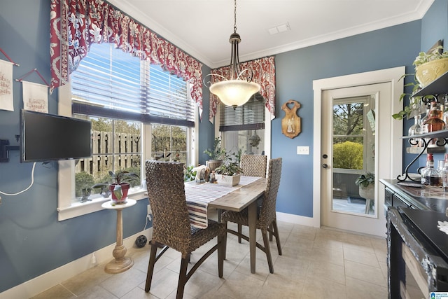 tiled dining area with visible vents, a healthy amount of sunlight, baseboards, and ornamental molding