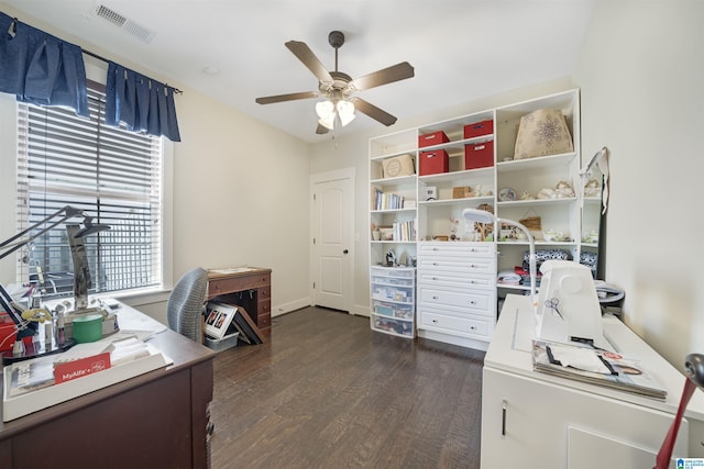 home office with dark wood-style floors, visible vents, and a ceiling fan