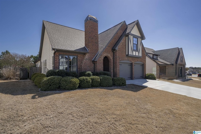 view of front of house with a front lawn, concrete driveway, an attached garage, brick siding, and a chimney