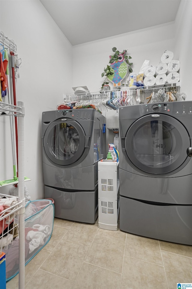 laundry area with laundry area, light tile patterned flooring, and washer and clothes dryer