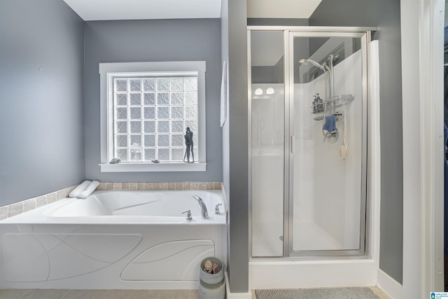 full bathroom featuring a bath, a stall shower, and a wealth of natural light