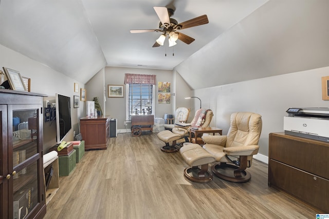 living area featuring vaulted ceiling, light wood-style floors, baseboards, and ceiling fan