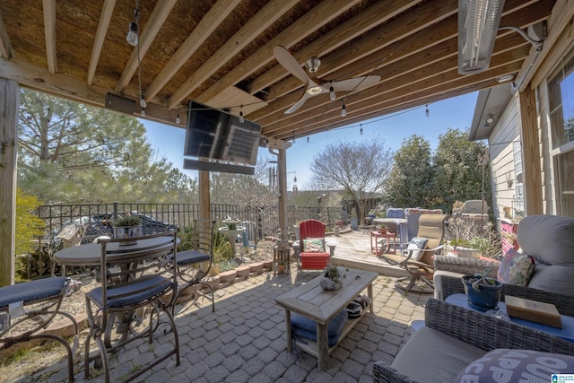 view of patio featuring a ceiling fan, outdoor dining area, fence, and an outdoor hangout area