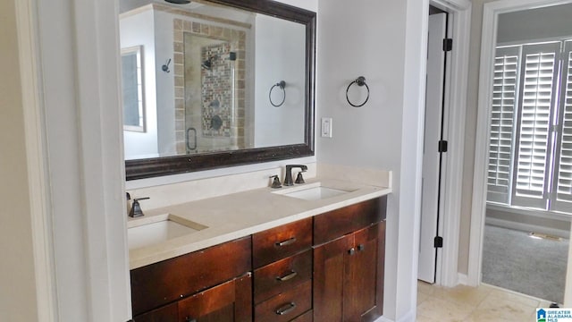 bathroom with double vanity, a stall shower, a sink, and tile patterned floors