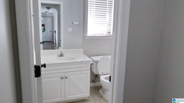 half bathroom featuring tile patterned flooring, vanity, and toilet