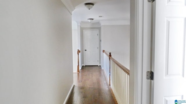 hallway featuring baseboards, wood finished floors, an upstairs landing, and crown molding