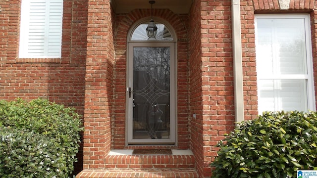 property entrance featuring a garage and brick siding