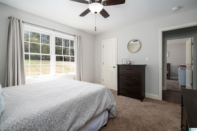 carpeted bedroom with ceiling fan and baseboards