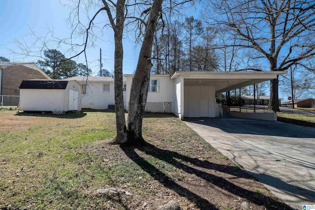 view of front of house featuring concrete driveway, crawl space, an outdoor structure, a front lawn, and a carport