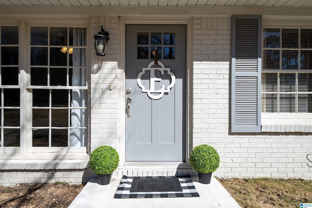 doorway to property featuring brick siding