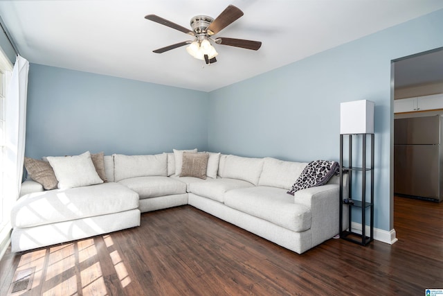 living room with ceiling fan, dark wood-style flooring, and baseboards