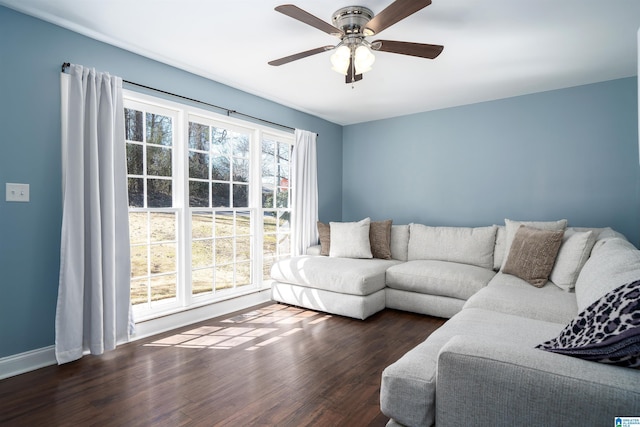 living room with ceiling fan, baseboards, and wood finished floors