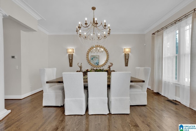 dining area featuring visible vents, crown molding, an inviting chandelier, and wood finished floors