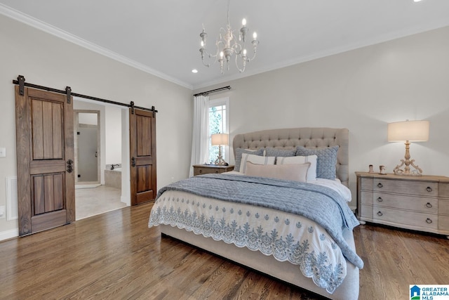 bedroom with a notable chandelier, visible vents, a barn door, ornamental molding, and wood finished floors