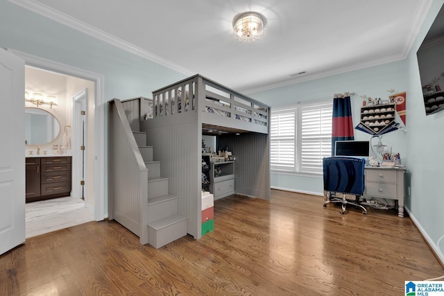 unfurnished bedroom with a sink, ornamental molding, wood finished floors, and visible vents