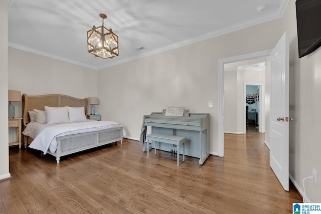 bedroom with crown molding, visible vents, a chandelier, and wood finished floors