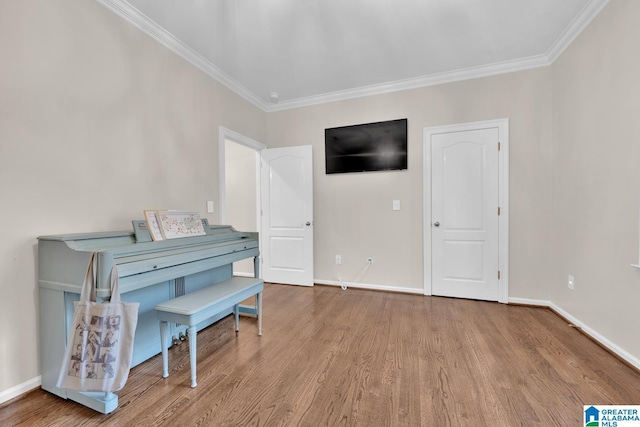 sitting room with crown molding, baseboards, and wood finished floors