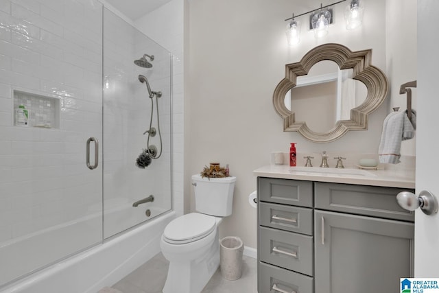 full bathroom with tile patterned flooring, toilet, shower / bath combination with glass door, vanity, and baseboards