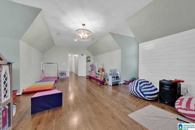 rec room featuring vaulted ceiling, wood finished floors, and a notable chandelier