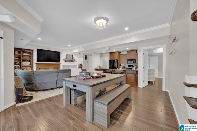 dining room featuring crown molding, baseboards, and wood finished floors